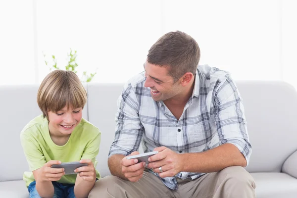 Vader en zoon spelen op mobiele telefoon — Stockfoto