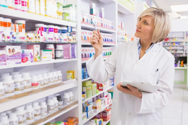 Blonde pointant des médicaments avec son stylo — Photo