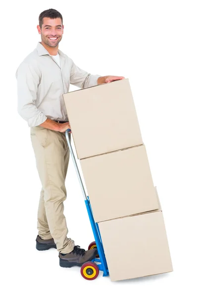 Happy delivery man with trolley of boxes — Stock Photo, Image