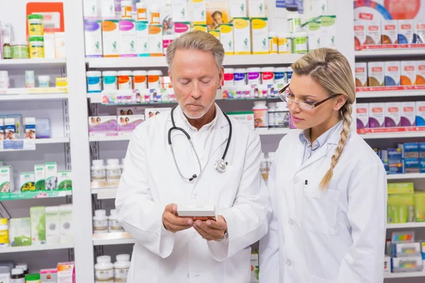 Farmacéutico hablando con su aprendiz sobre medicina — Foto de Stock