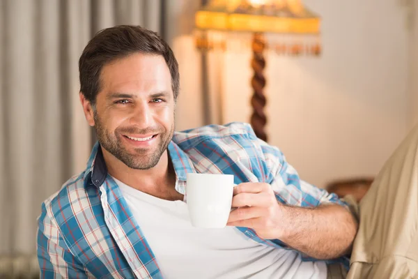 Homem relaxante na cama com bebida quente — Fotografia de Stock