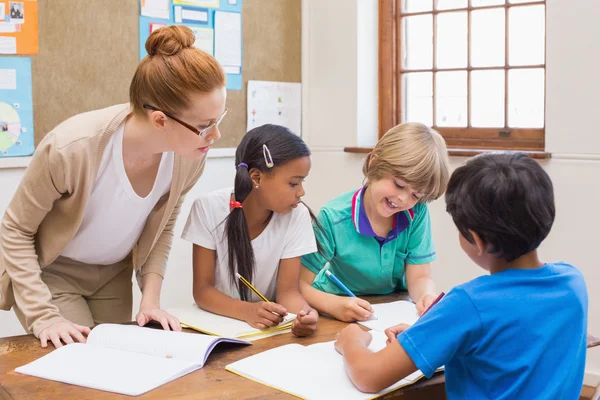 Leraar en leerlingen samen te werken aan balie — Stockfoto