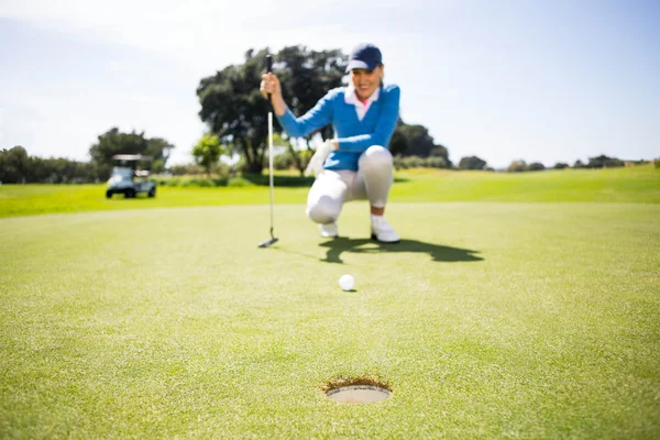 彼女のボールを置く女性ゴルファー — ストック写真