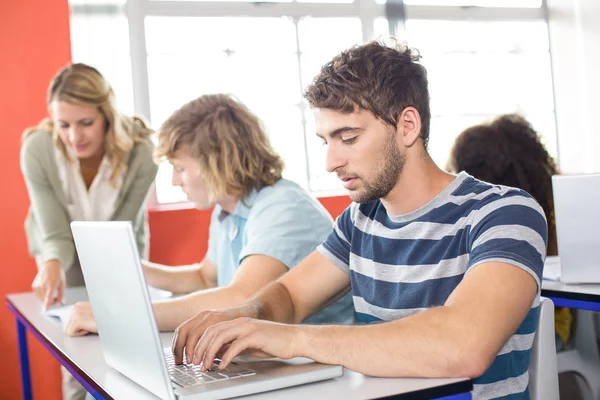 Student met behulp van laptop in de klas — Stockfoto