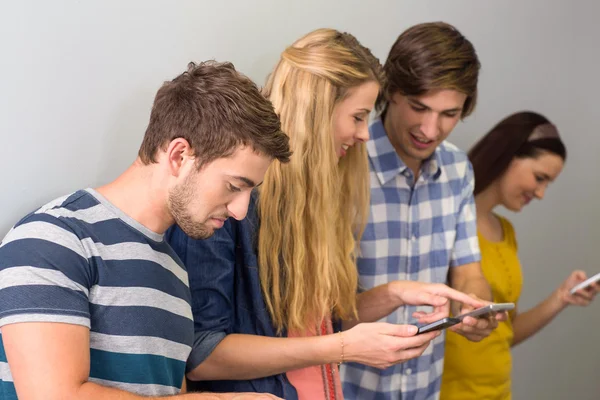 Студенты колледжей используют мобильные телефоны — стоковое фото