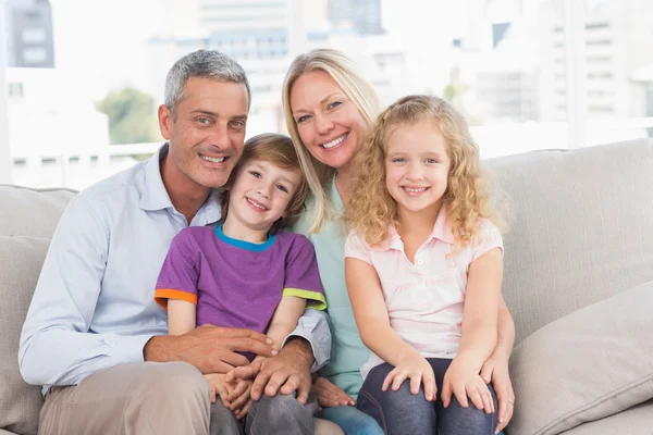 Gelukkig gezin zitten op de bank thuis — Stockfoto
