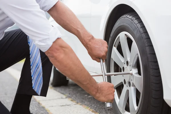 Businessman fixing tire — Stock Photo, Image