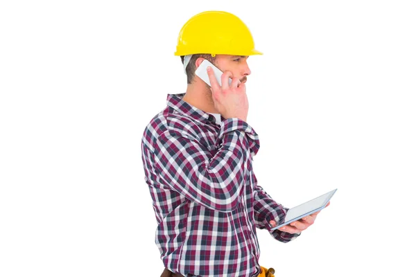 Repairman on phone holding tablet pc — Stock Photo, Image