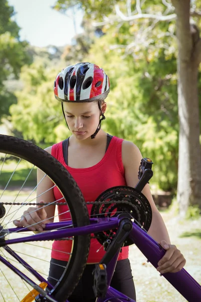 Adatta donna che fissa la catena in bicicletta — Foto Stock