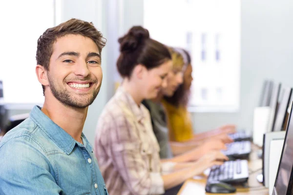 Student som ler mot kameran i datorn klass — Stockfoto