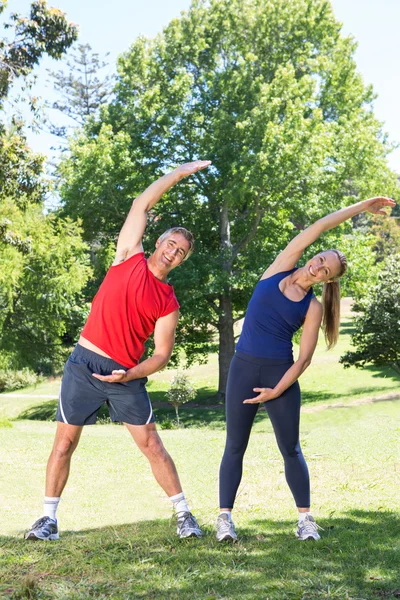 S'adapter couple étirement dans le parc — Photo