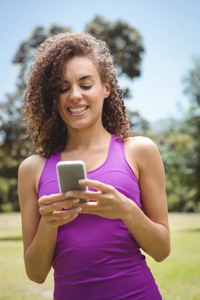 Adatta donna al telefono nel parco — Foto Stock