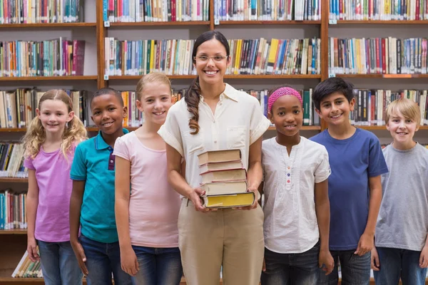 Cute pupils and teacher having class in library — Stock Photo, Image