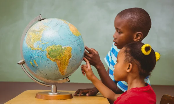 Crianças apontando para o globo em sala de aula — Fotografia de Stock