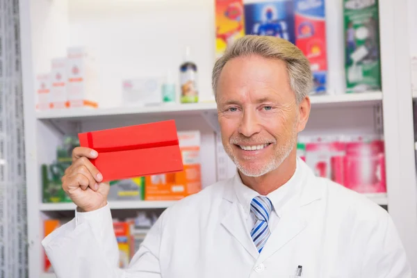 Smiling senior pharmacist presenting paper — Stock Photo, Image