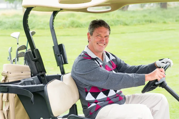 Happy golfer driving his golf buggy — Stock Photo, Image