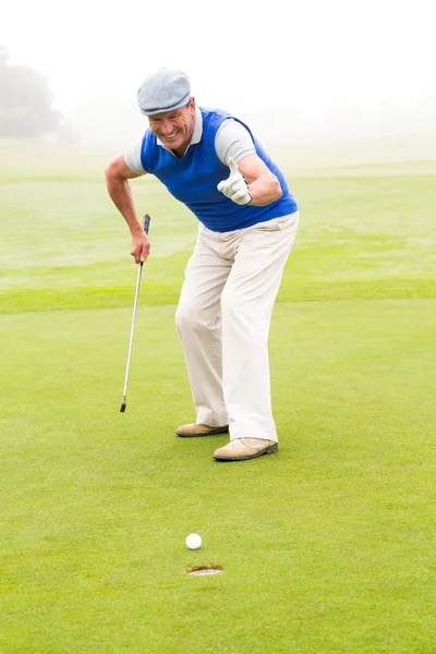 Happy golfer cheering on putting green Stock Picture