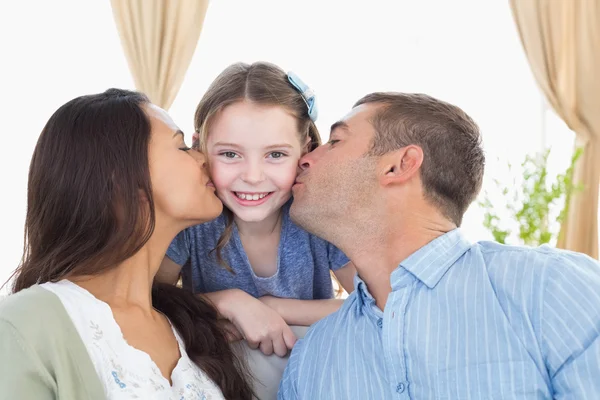 Menina feliz sendo beijada pelos pais — Fotografia de Stock