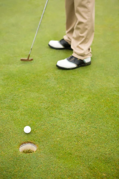 Golfer on the putting green at the hole Stock Picture