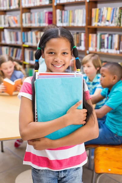 Aluno bonito sorrindo para a câmera na biblioteca — Fotografia de Stock