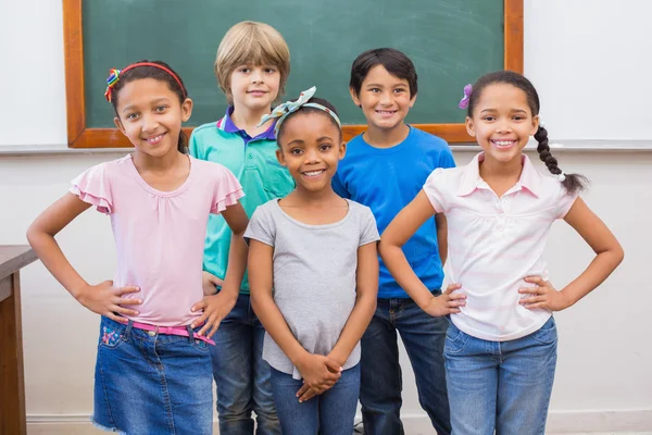 Mignons élèves souriant à la caméra dans la salle de classe — Photo