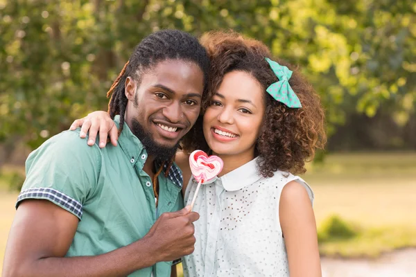 Linda pareja en el parque compartiendo una piruleta — Foto de Stock