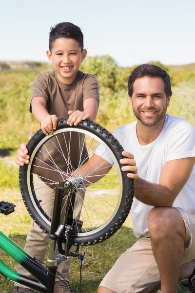 Pai e filho reparando bicicleta juntos — Fotografia de Stock