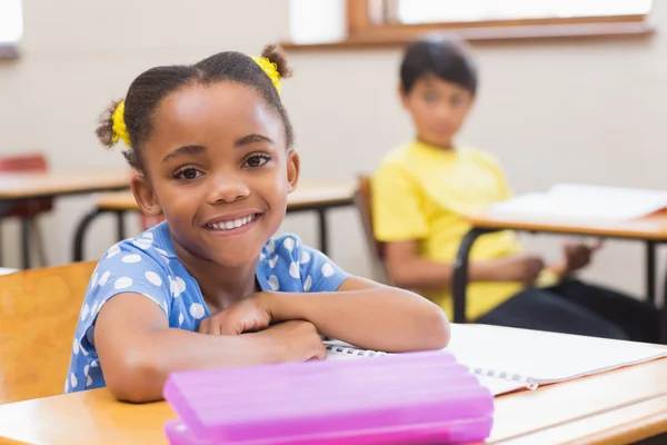Uśmiechający się uczeń siedział przy biurku — Zdjęcie stockowe