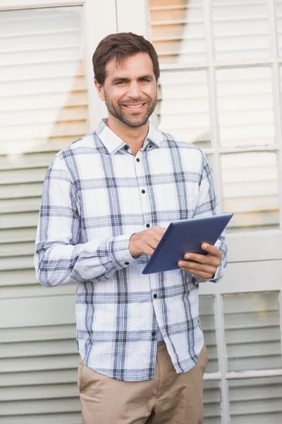 Homem sorrindo para câmera segurando tablet — Fotografia de Stock