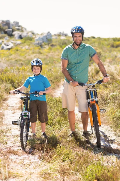 Père et fils faisant du vélo à travers les montagnes — Photo