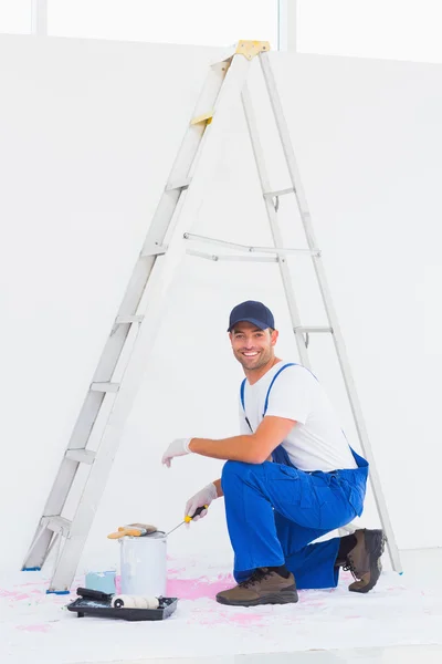 Handyman i overaller öppna paint kan — Stockfoto