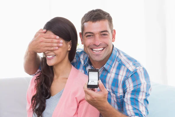 Szczęśliwy człowiek obejmujących oczy womans podczas gifting pierścień — Zdjęcie stockowe