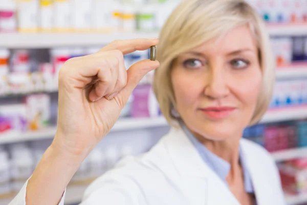 Blonde pharmacist in lab coats showing pill — Stock Photo, Image