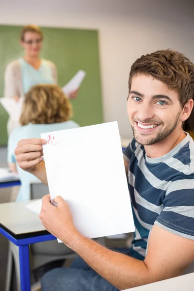 Щасливий студент тримає папір — стокове фото