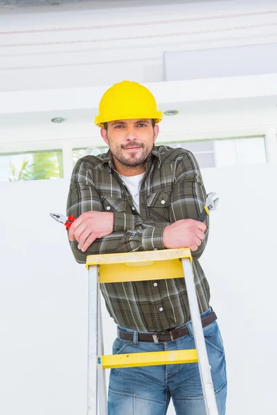 Repairman with pliers on ladder — Stock Photo, Image