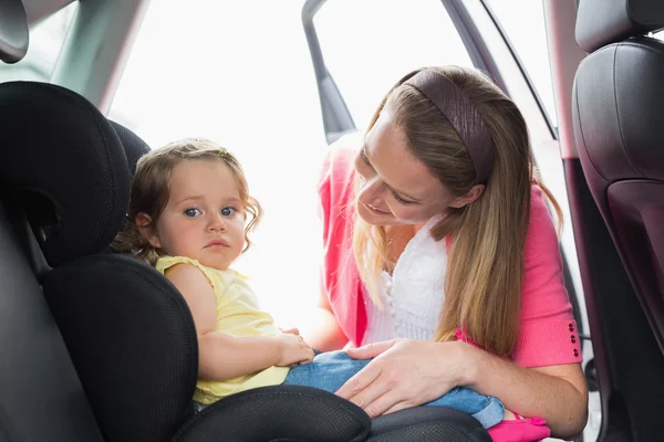 Madre che fissa il suo bambino sul seggiolino auto — Foto Stock