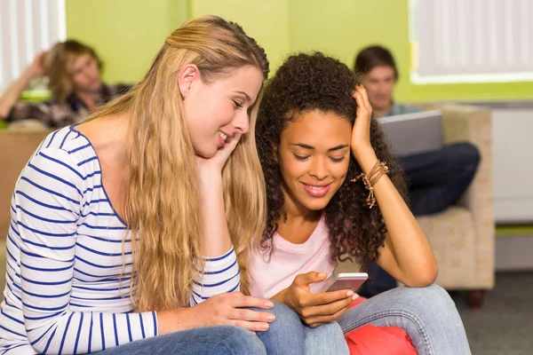 Unga kvinnor textmeddelanden i office — Stockfoto