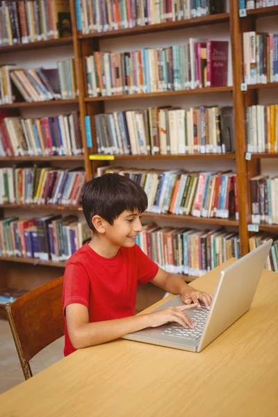 Junge benutzt Laptop in der Bibliothek — Stockfoto