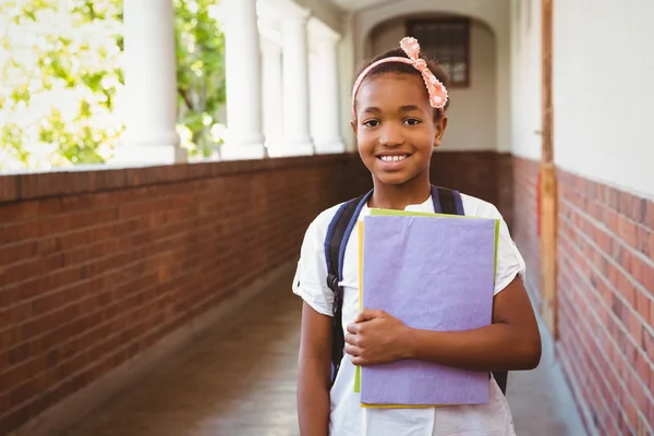 Dziewczynka gospodarstwa foldery w szkolnym korytarzu — Zdjęcie stockowe