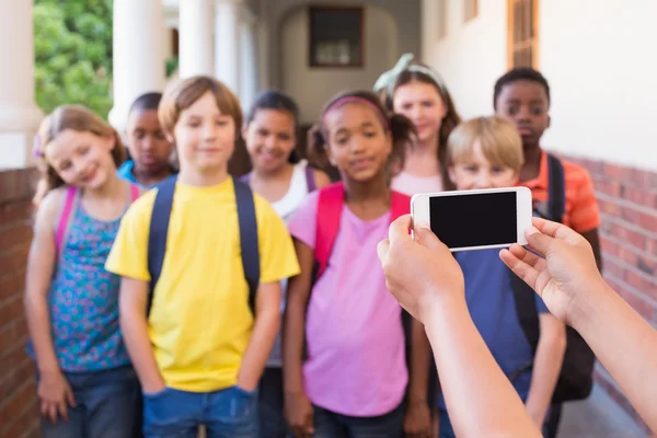 Cute pupils using mobile phone — Stock Photo, Image