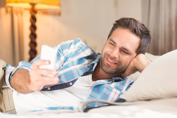 Knappe man ontspannen op zijn bed — Stockfoto