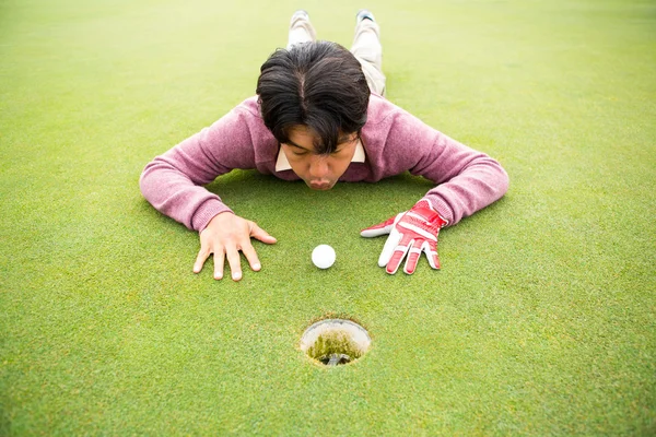 Golfista tentando atirar bola para o buraco — Fotografia de Stock