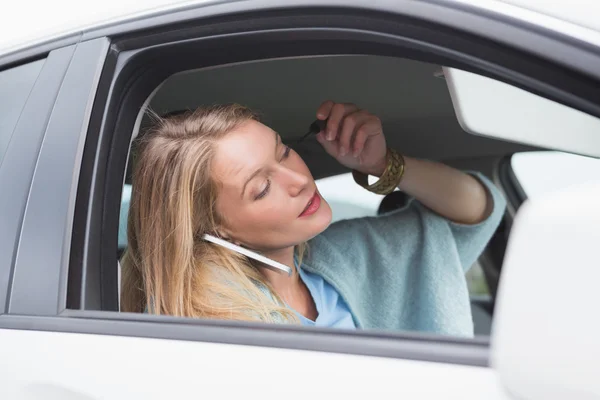 Young woman putting on makeup while calling — Stock Photo, Image