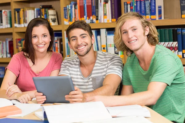 Estudiantes universitarios usando tableta digital en la biblioteca — Foto de Stock