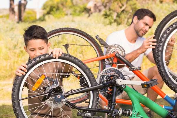Pai e filho reparando bicicleta juntos — Fotografia de Stock