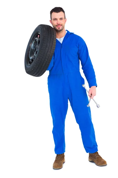 Smiling male mechanic holding tire — Stock Photo, Image