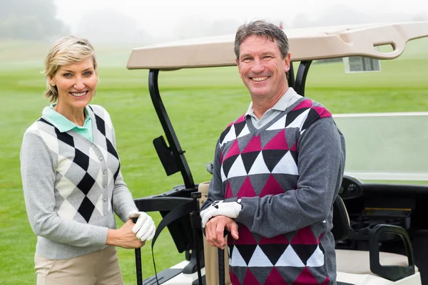 Golfen paar met golf buggy achter — Stockfoto