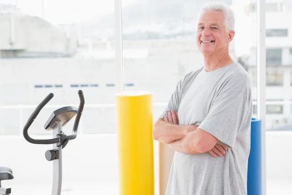 Uomo anziano sorridente con le braccia incrociate — Foto Stock