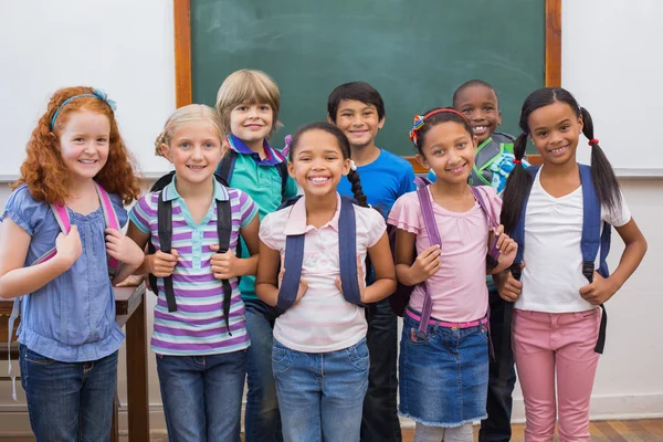 Cute pupils smiling at camera in classroom — Stock Photo, Image