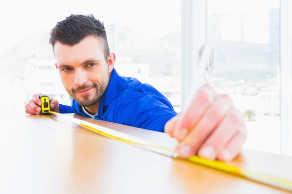 Handyman measuring wood board — Stock Photo, Image